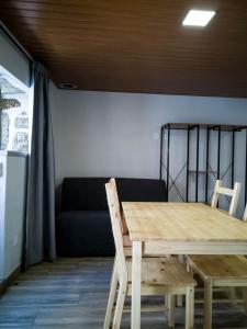 a table and chairs in a room with a couch at Casa dos Trenós in Sabugueiro