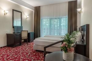 Cette chambre comprend un lit et un bureau. dans l'établissement Rediu Hotel & Restaurant, à Botoşani
