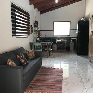 a living room with a couch and a screen at Chácara buriti in Pirenópolis +30 photos