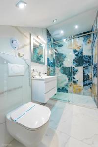 a white bathroom with a toilet and a shower at Risteski Apartments - St. Naum in Ohrid +28 photos