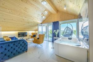 a large bathroom with a tub and a blue couch at Risteski Apartments - St. Naum in Ohrid