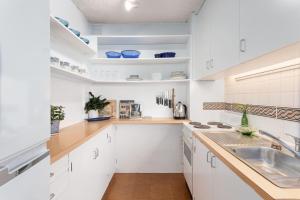 a kitchen with white cabinets and a sink at Paddington Pad in Sydney