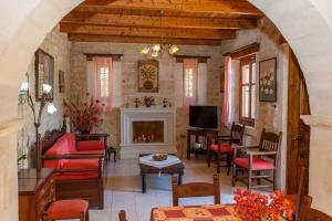 a living room with a fireplace and red chairs at Villa Phaedra in Prinés