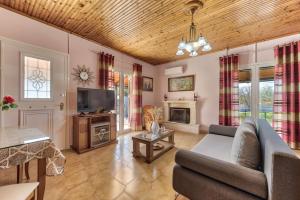 Una sala de estar con un sofá y un televisor en Toscana Villas, en Gaïtánion