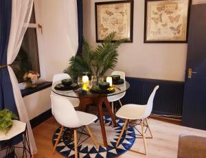 a dining room with a table and white chairs at Cosy 3 bedroom flat in City Centre in Glasgow