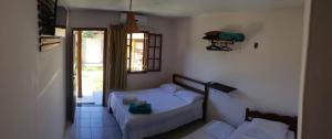 ein kleines Schlafzimmer mit einem Bett und einem Fenster in der Unterkunft Pousada Mixirica in Trindade