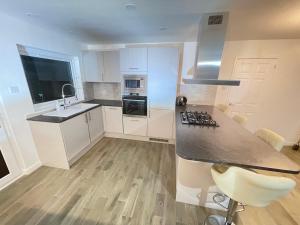 a kitchen with white cabinets and a counter top at Matara House Holiday Home in Inverness