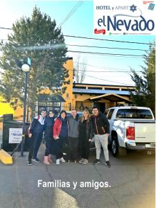 um grupo de pessoas posando para uma foto em um estacionamento em Apart El Nevado Malargüe em Malargüe