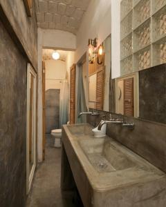 uma casa de banho com um grande lavatório de pedra e um WC em My Sisters House - Female only em Sayulita