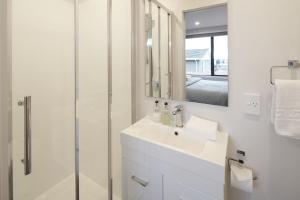 a white bathroom with a sink and a shower at Shepherd's View - Lake Tekapo in Lake Tekapo +6 photos