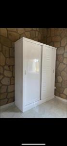 a white refrigerator in front of a stone wall at Nile palace villa in Luxor