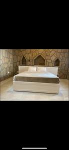 a large bed in a room with a stone wall at Nile palace villa in Luxor
