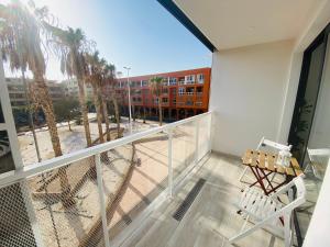 a balcony with a view of a building and palm trees at Apartamento de obra nueva cerca de la playa by Top Stay in El Médano