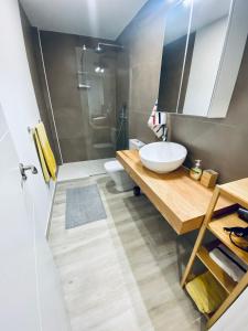 a bathroom with a sink and a toilet and a mirror at Apartamento de obra nueva cerca de la playa by Top Stay in El Médano +16 photos