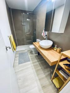a bathroom with a sink and a toilet and a mirror at Apartamento de obra nueva cerca de la playa by Top Stay in El Médano