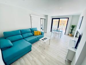 a living room with a blue couch and a table at Apartamento de obra nueva cerca de la playa by Top Stay in El Médano