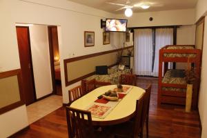 Habitación con mesa, sillas y sala de estar. en Apart Hotel Family en Mar del Plata