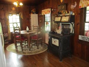 普林斯顿Cabin retreat just off I-77, wonderful experience for 2!的客房设有燃木炉、桌子和椅子。
