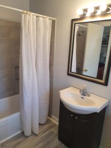 a bathroom with a sink and a mirror at Gateway Motel in Gananoque