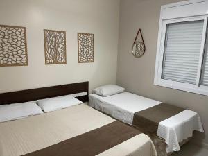 a room with two beds and a window at Apto Beira Mar 3D in Capão da Canoa