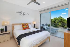 - une chambre avec un lit et un balcon avec une télévision dans l'établissement Sunshine Beach Retreat - 3 Bedroom Family Apartment - Wifi - Netflix - 2 Cars, à Sunshine Beach