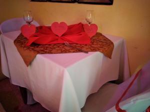 a table with two wine glasses and red bows on it at HOTEL VALLE SAGRADO in Vilcabamba