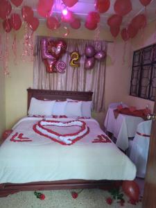 a bedroom with a bed with red and pink balloons at HOTEL VALLE SAGRADO in Vilcabamba