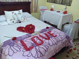 a bed with flowers on it with two tables at HOTEL VALLE SAGRADO in Vilcabamba