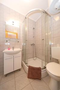 a bathroom with a shower and a toilet and a sink at Rooms Zdravko in Stara Novalja +28 photos