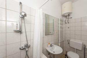 a bathroom with a shower curtain and a sink at Bungalow Small House in Stara Novalja +17 photos