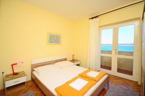 um quarto com uma cama e uma grande janela em Apartments Marinko em Barbat na Rabu