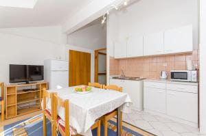 een keuken met een tafel en een fruitschaal bij Apartments Zoran in Drvenik