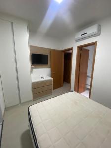sypialnia z łóżkiem i telewizorem w pokoju w obiekcie Apartamento Praia Grande w mieście Ubatuba