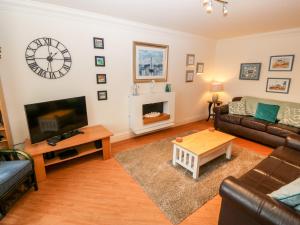 a living room with a couch and a tv at Linksway in Morfa Nefyn