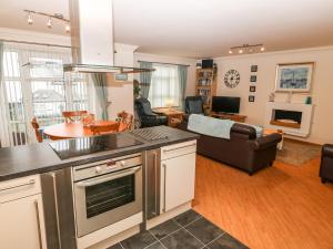 a kitchen and a living room with a couch at Linksway in Morfa Nefyn