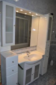 a white bathroom with a sink and a mirror at Apartment Milka - 150 m from sea in Biograd na Moru