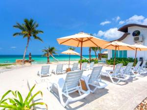 The Samui Beach Resort في كوه ساموي: مجموعة من الكراسي والمظلات على الشاطئ