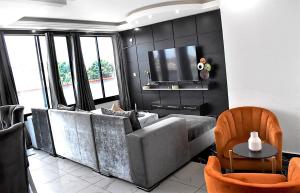 a living room with a couch and a flat screen tv at Résidence L'écrin in Yaoundé