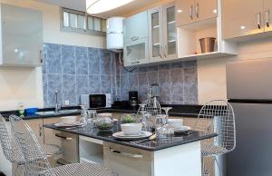 a kitchen with a table and chairs in a kitchen at Résidence L'écrin in Yaoundé