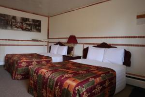 a hotel room with two beds and a lamp at Vista Motel in Vegreville