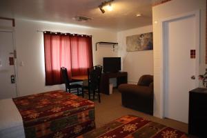 a hotel room with a bed and a couch and a table at Vista Motel in Vegreville