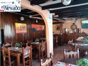 a restaurant with wooden tables and chairs in a room at Hotel El Nevado, Malargüe Mendoza in Malargüe