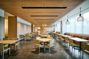 a dining room with tables and chairs and windows at The Royal Park Hotel Kyoto Umekoji in Kyoto