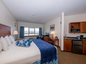 a hotel room with a large bed and a kitchen at Sea Latch Inn in York Beach