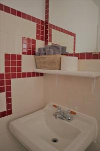 a white sink in a bathroom with red tiles at Vista Motel in Vegreville +9 photos