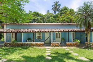a blue house with a yard in front of it at Vila Siriúba Hotel in Ilhabela