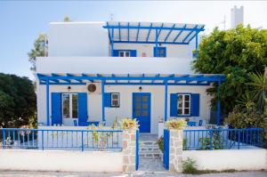 ein blau-weißes Haus mit einem blauen Zaun in der Unterkunft Helen's Budget Accommodation in Aliki