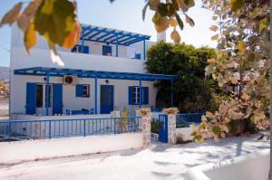una casa azul y blanca con una valla azul en Helen's Budget Accommodation, en Aliki