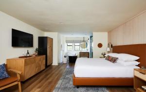 a bedroom with a large white bed and a television at The Stavrand in Guerneville