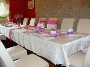una mesa con un mantel blanco y flores rosas. en Ośrodek Pegaz, en Duszniki-Zdrój